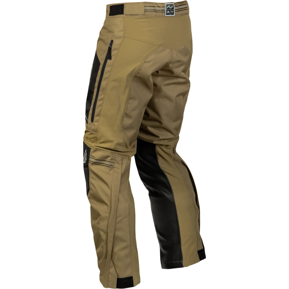 Side view of tactical pants in tan and black, featuring a zippered pocket on the left thigh and a small logo patch on the waistband.