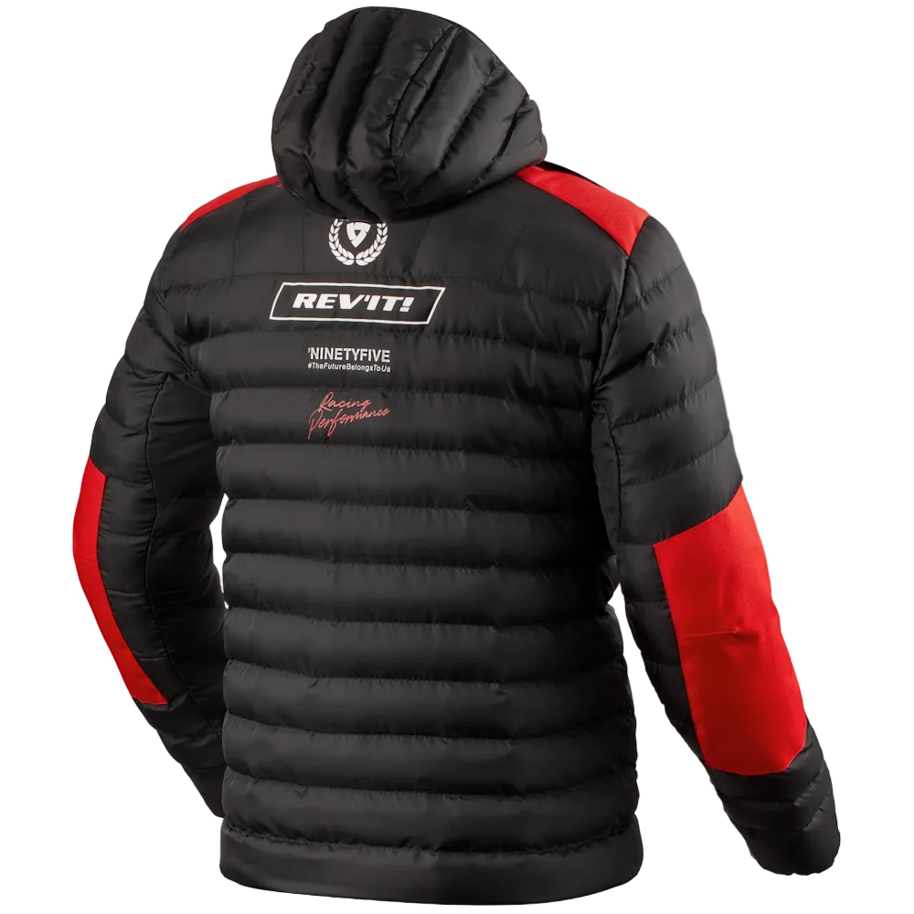 A black puffer jacket with red color-blocked panels on the shoulders and lower sleeves, featuring white and red REV'IT! branding on the back, shown against a light off-white background.