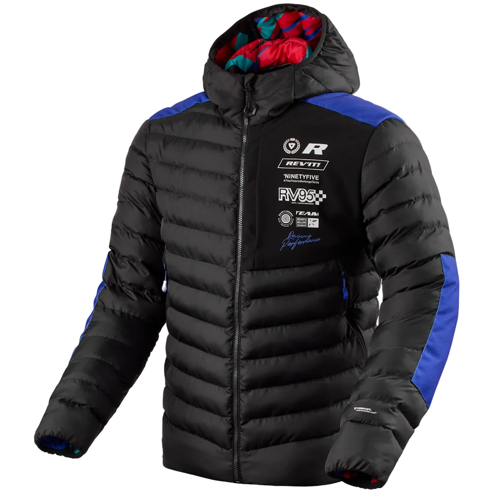 A black puffer jacket with blue panels on the shoulders and sleeves, featuring a hood with a red and teal lining and multiple racing-style sponsor logos on the left chest, shown on a light gray background.