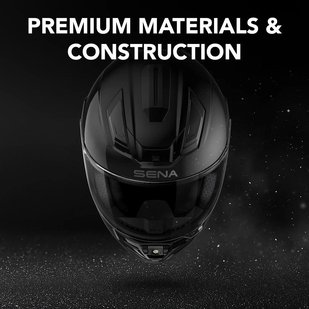 A black full-face motorcycle helmet centered on a dark background with the text 'PREMIUM MATERIALS & CONSTRUCTION' at the top and the SENA brand name visible on the visor area.