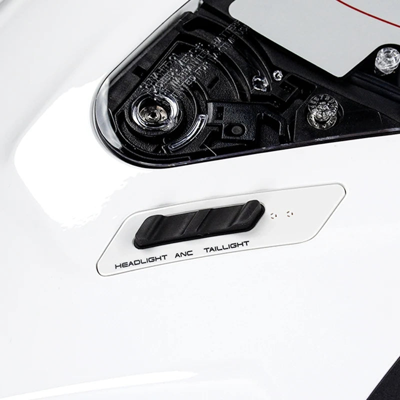 Close-up of a white car body panel showing the headlight assembly and a black plastic switch labeled HEADLIGHT ANC TAILLIGHT.