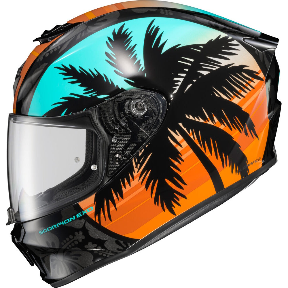 A full-face motorcycle helmet featuring a tropical sunset design with black palm tree silhouettes over a gradient of turquoise, orange, and yellow, with a clear visor.