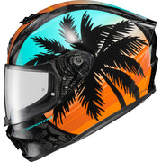 A full-face motorcycle helmet featuring a tropical sunset design with black palm tree silhouettes over a gradient of turquoise, orange, and yellow, with a clear visor.