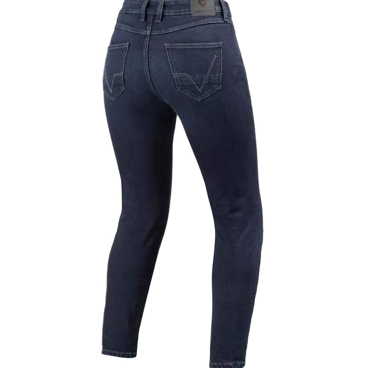 Rear view of dark blue skinny jeans on a light beige background.