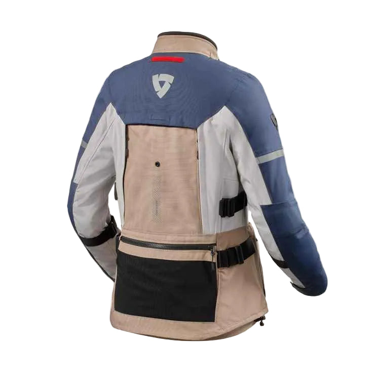Rear view of a technical motorcycle jacket in beige, blue, and white, featuring a black lower panel and a small red accent on the upper back.