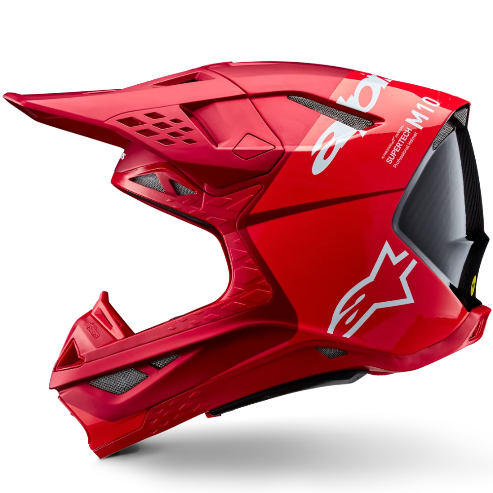 A red full-face motocross helmet with a visor, featuring white Alpinestars branding and 'M10' text, shown from a side profile on a white background.