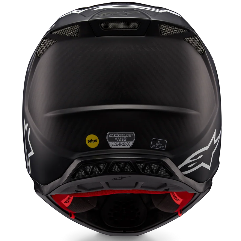 Rear view of a black full-face motorcycle helmet with a carbon fiber pattern visor, white Alpinestars graphics, and red interior lining, shown on a white background.