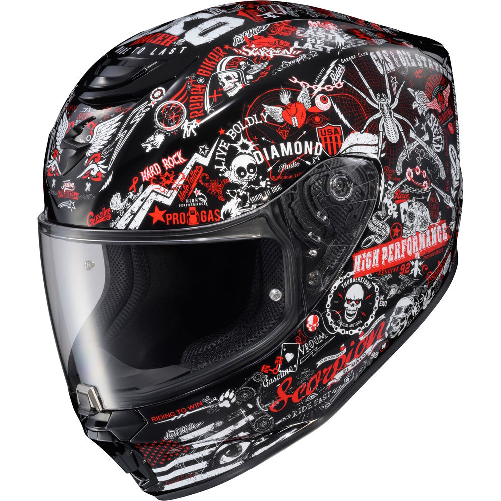 A full-face motorcycle helmet with a black base color and a detailed graphic print featuring red, white, and gray elements, including skulls, gears, and various text decals.