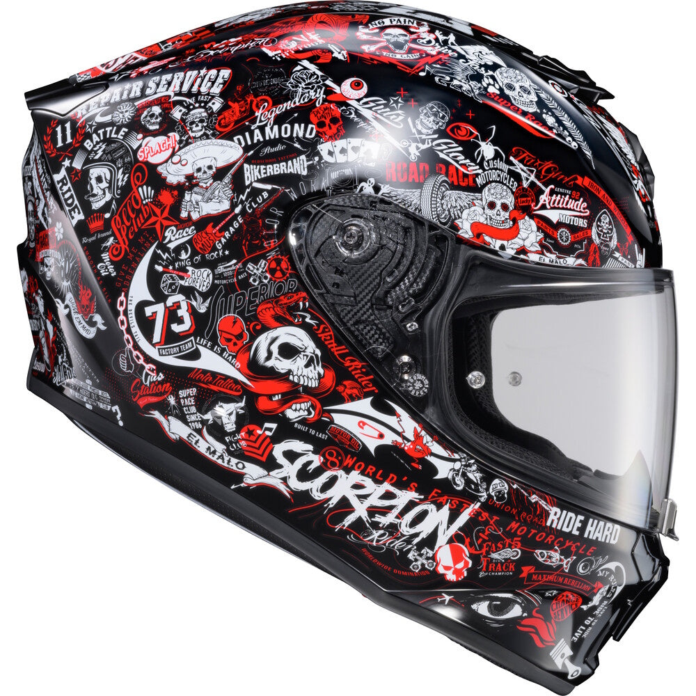 A full-face motorcycle helmet with a black base and an all-over red, white, and gray graphic collage featuring skulls, graffiti-style text, and motorcycle-themed illustrations.