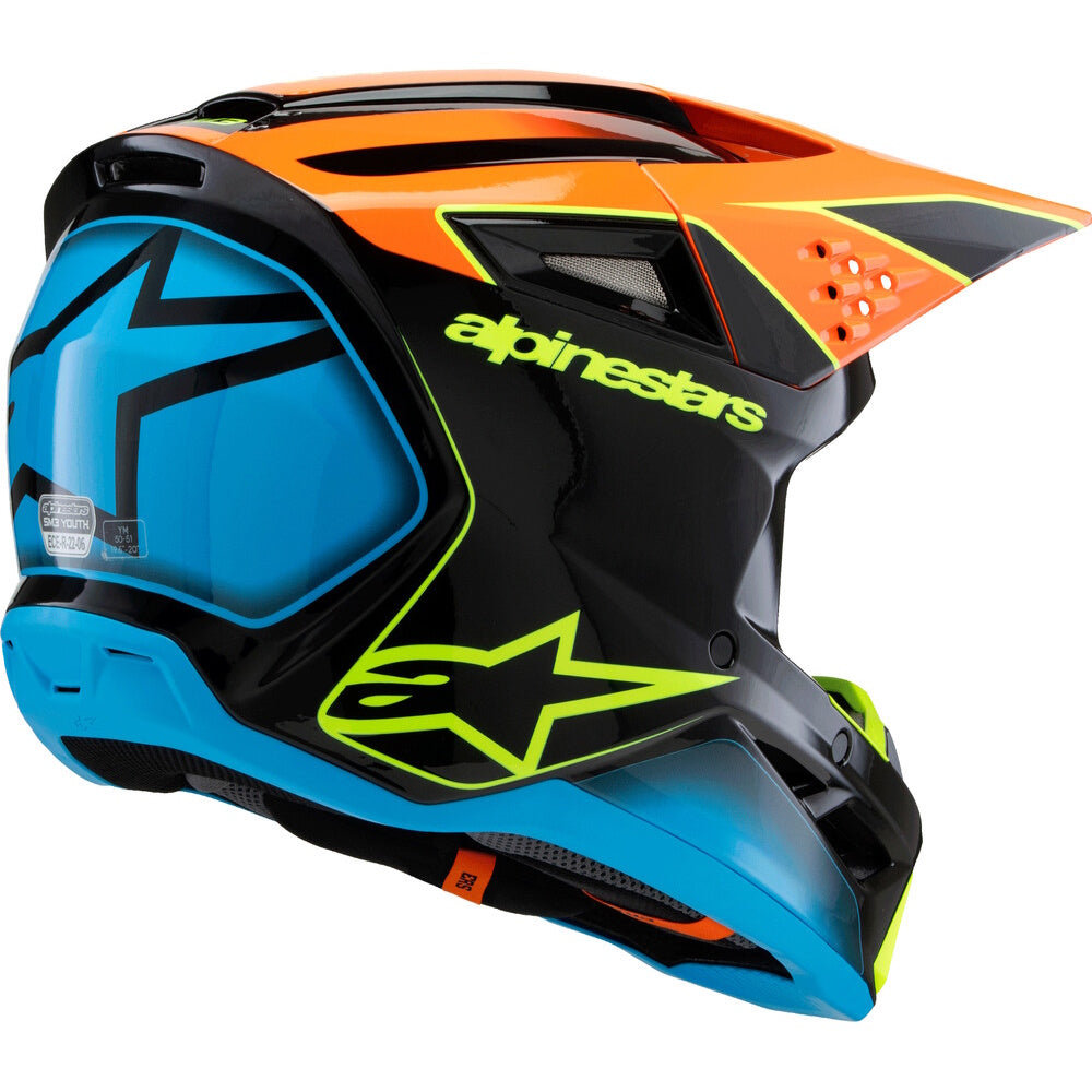 Alpinestars full-face motocross helmet in black, orange, and blue with neon yellow-green accents, featuring a clear visor and the Alpinestars logo.