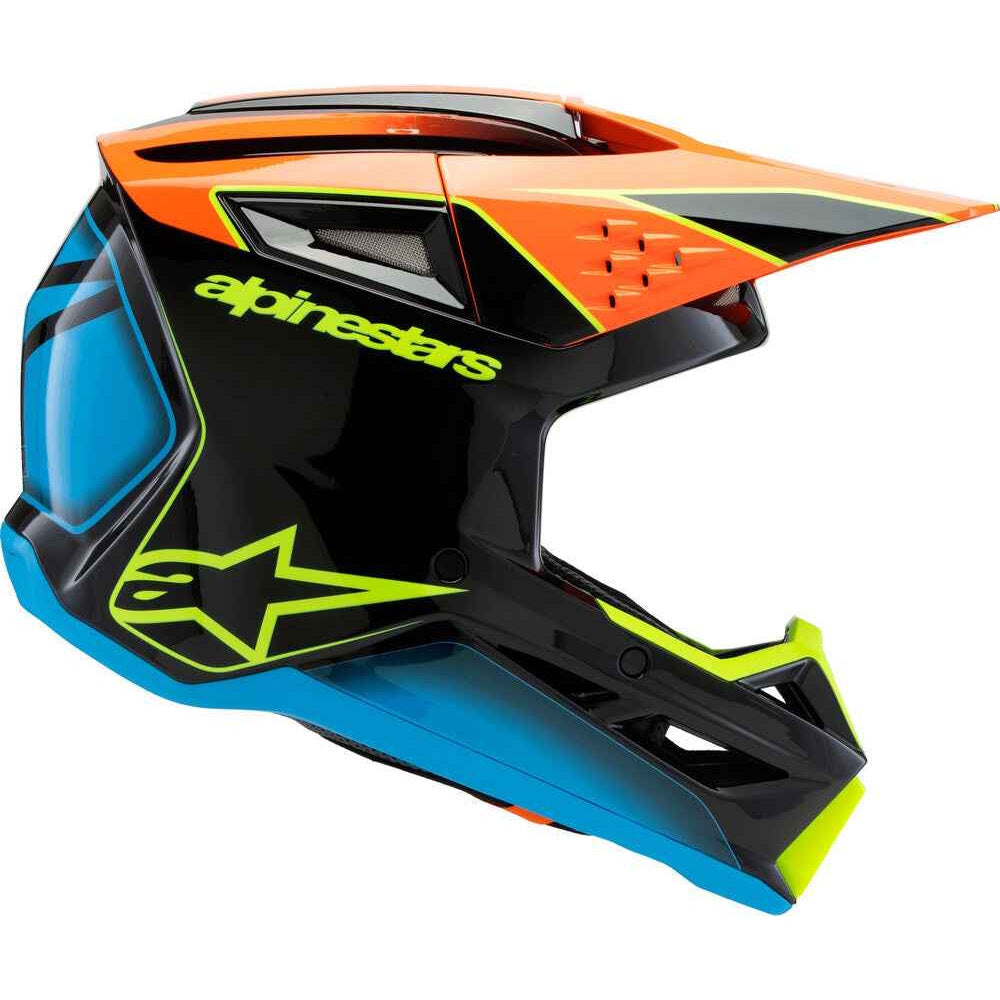 Alpinestars motocross helmet in a striking black, orange, and blue colorway with neon yellow-green accents, shown from a three-quarters angle on a white background.