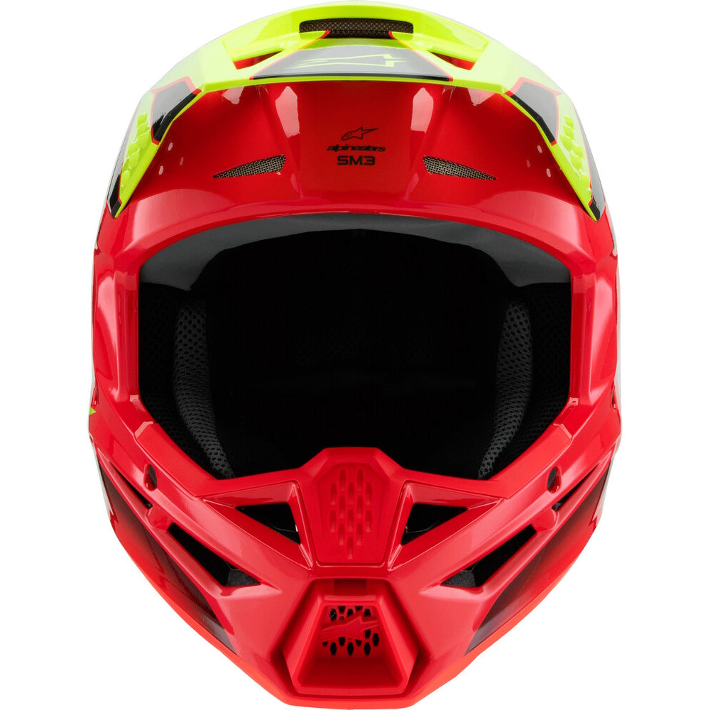 A red and neon yellow Alpinestars full-face motocross helmet with a black visor and interior padding, shown from a three-quarters angle on a white background.