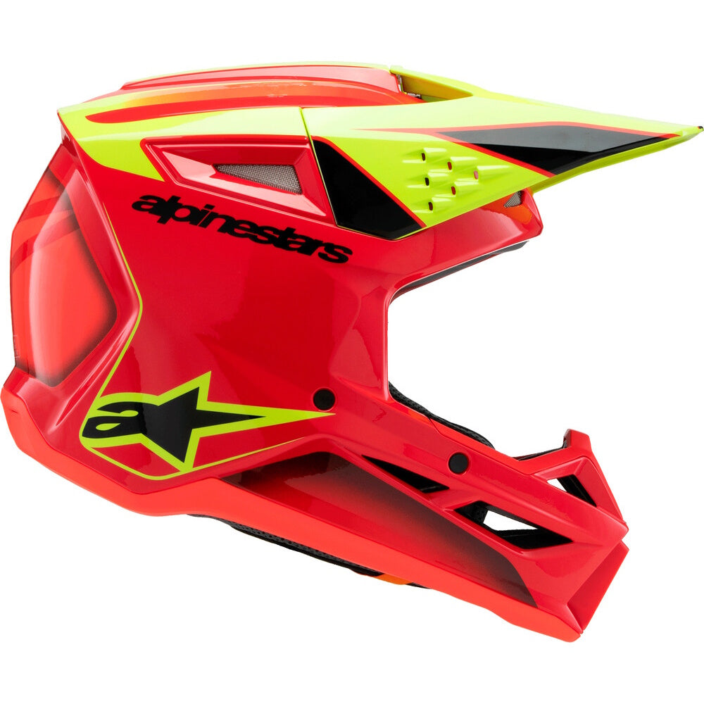 A red and neon yellow Alpinestars motocross helmet with black accents, shown from a three-quarters angle on a white background.