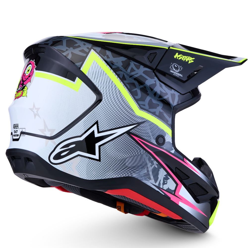 A motocross helmet by Alpinestars and Kork Factory, featuring a white, gray, and black graphic pattern with neon yellow, pink, and red accents, shown on a white background.