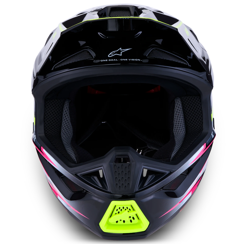 A full-face motocross helmet in glossy black with vibrant neon lime green accents on the chin and visor trim, and subtle pink graphic lines on the lower sides. The Alpinestars logo is visible on the forehead.