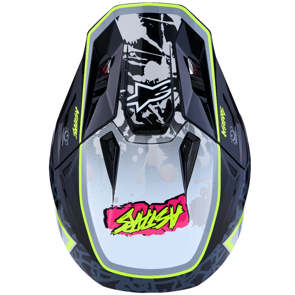 A top-down view of a motocross helmet featuring a black and white graphic pattern with neon yellow-green accents and a pink and yellow 'SHUSHY' logo on the front.