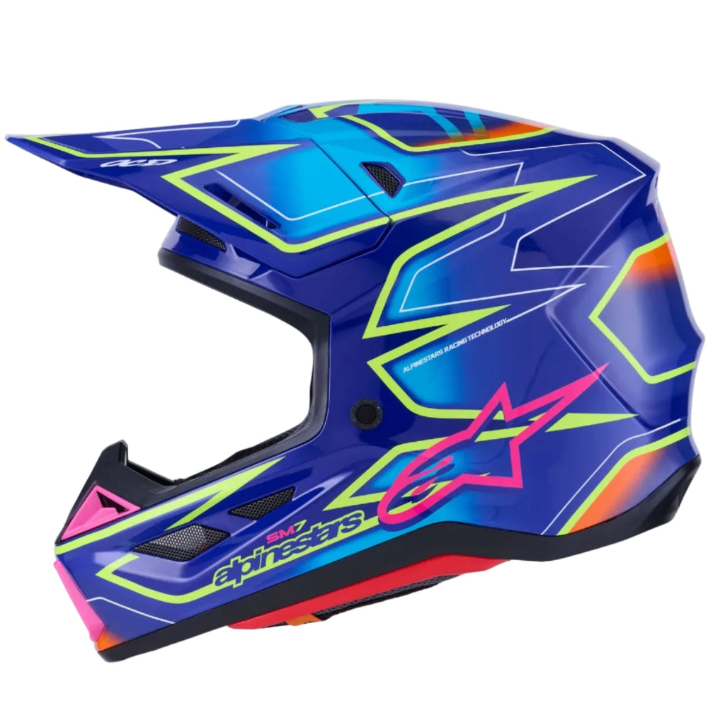 Alpinestars full-face motocross helmet in a vibrant blue colorway with neon yellow, pink, and orange graphic accents, shown from a side profile on a white background.