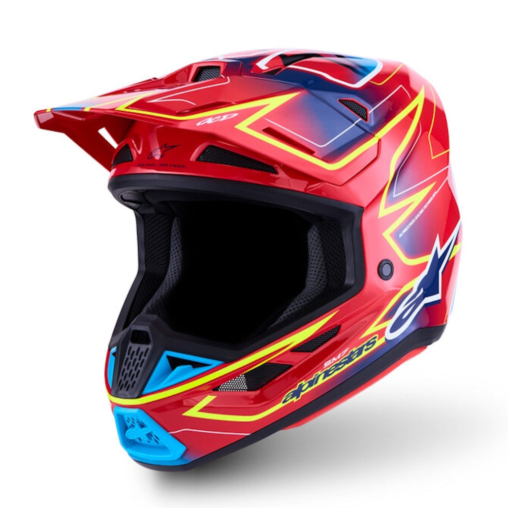 A red full-face motocross helmet with blue and yellow graphic accents, shown from a three-quarters angle on a white background.
