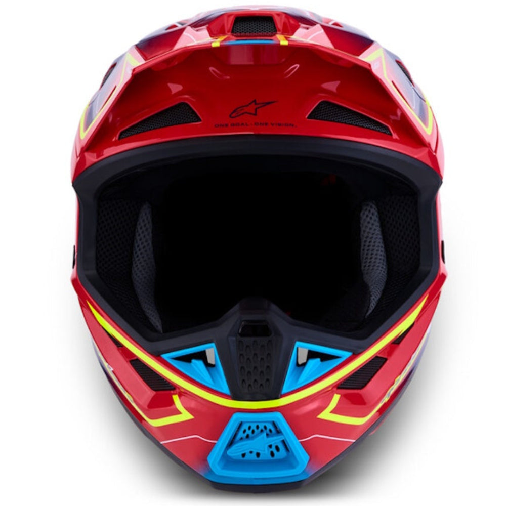 A red full-face motocross helmet with a black visor and blue, yellow, and white graphic accents, photographed from the front on a white background.