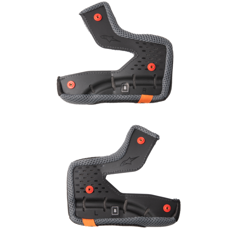 Two black off road helmet cheek pads with red snaps on a white background