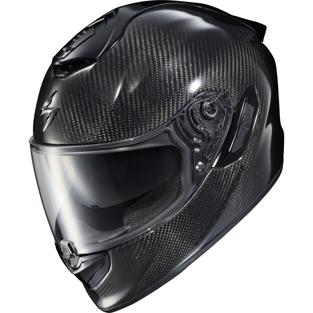 A full-face motorcycle helmet featuring a glossy black carbon fiber weave pattern, a clear visor, and a small silver logo on the side, shown against a plain white background.