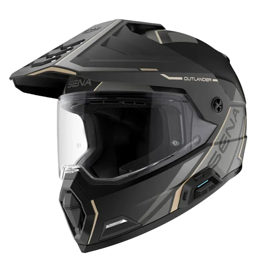 A black full-face off-road motorcycle helmet with gold accents and a clear visor, shown from a three-quarters angle on a light gray background. The brand 'SENA' and model 'OUTLANDER' are visible on the helmet.