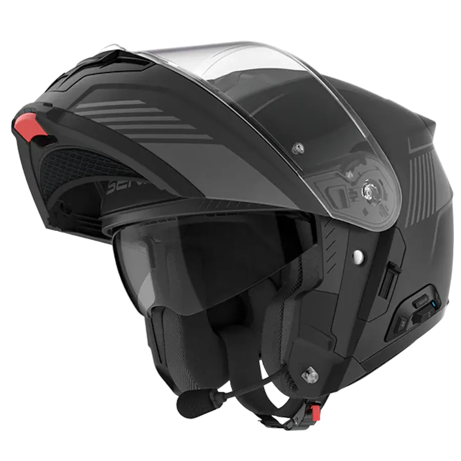 A black modular motorcycle helmet with an integrated clear visor, dark tinted goggles, a mounted communication microphone, and a small red accent on the side, shown against a plain white background.