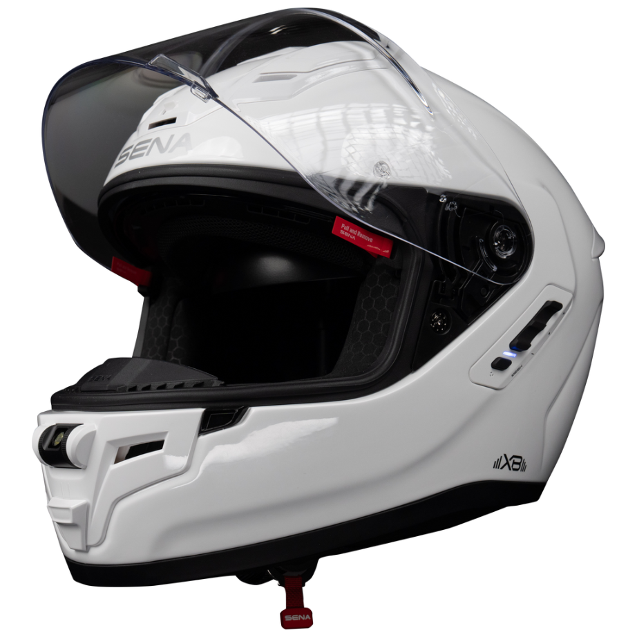 A white full-face motorcycle helmet with a clear visor, shown in a three-quarter view against a solid white background. The brand 'SENA' is visible on the forehead area and the visor hinge.