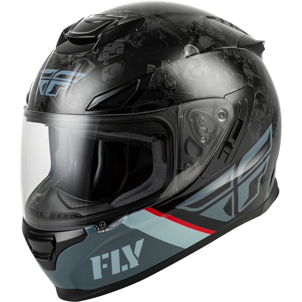 A full-face motorcycle helmet by Fly Racing, featuring a glossy black base with a subtle skull graphic pattern, light blue and gray graphic accents, and a clear visor.