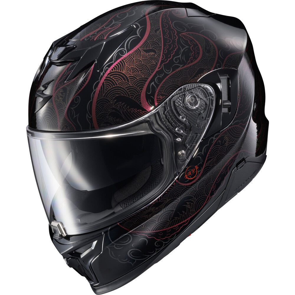 A full-face motorcycle helmet in glossy black with intricate red and gray wave-like patterns, featuring a clear visor, shown against a plain white background.