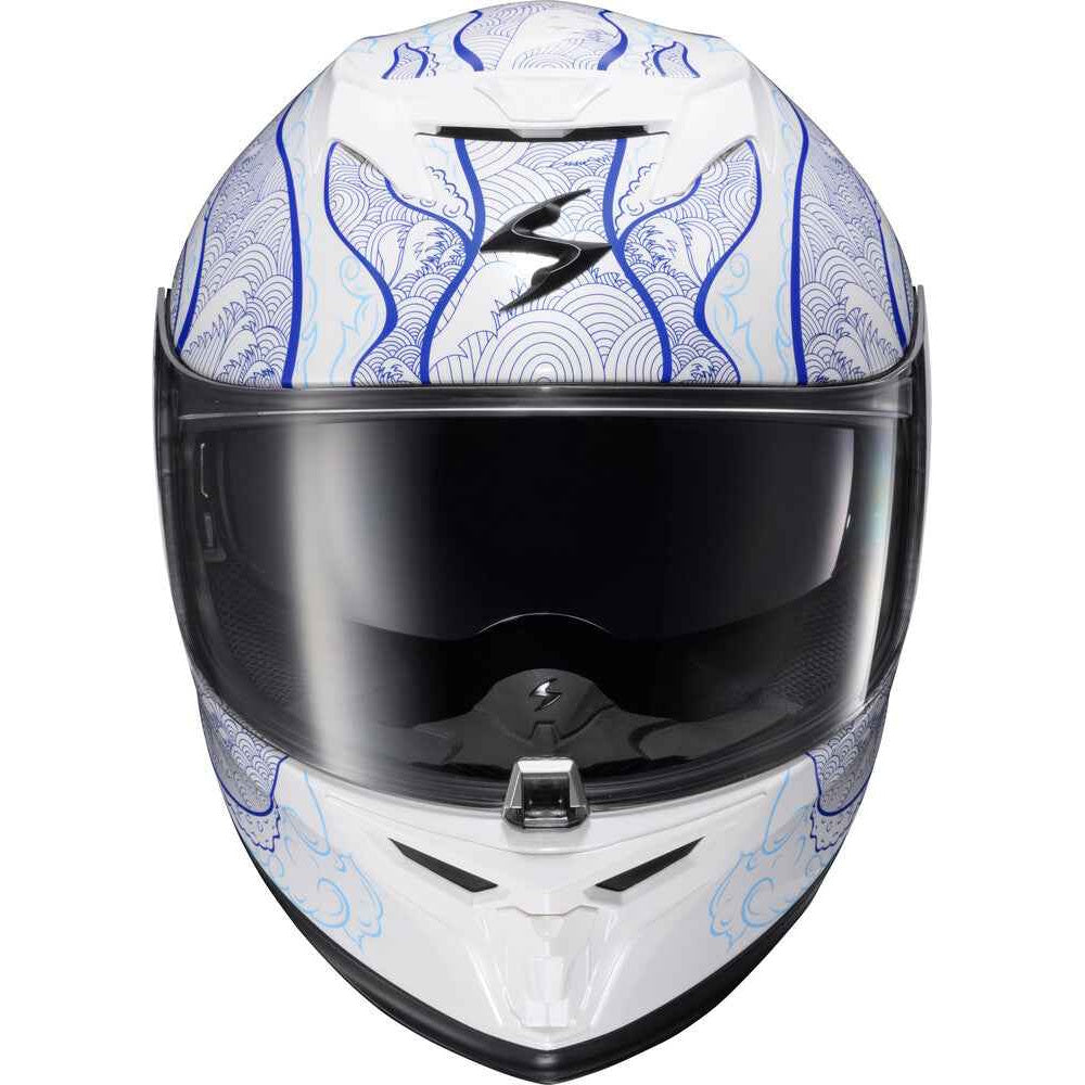 A full-face motorcycle helmet with a white base, decorated with blue wave patterns and a black stylized logo on the forehead, featuring a dark visor.