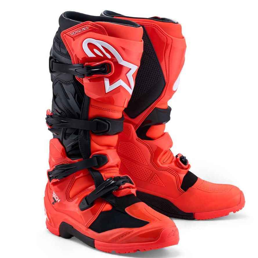 A pair of Alpinestars motocross boots in a vibrant red and black colorway, featuring the signature white Alpinestars star logo on the side, set against a clean white background.