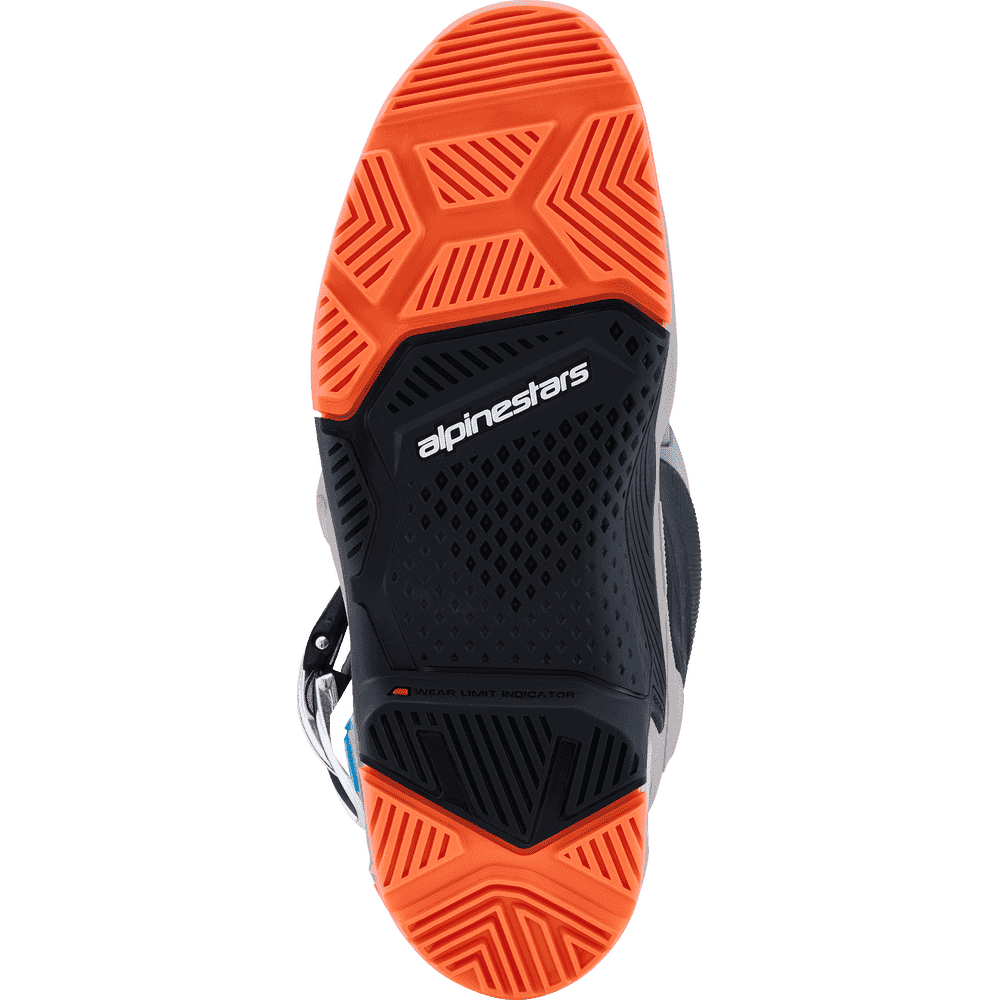 The outsole of an AlpineStars shoe, featuring a black textured central section with the white 'alpinestars' logo, flanked by bright orange rubber tread on a white background.