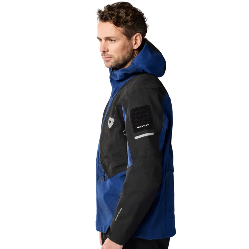 Man wearing a black and blue jacket on a white background