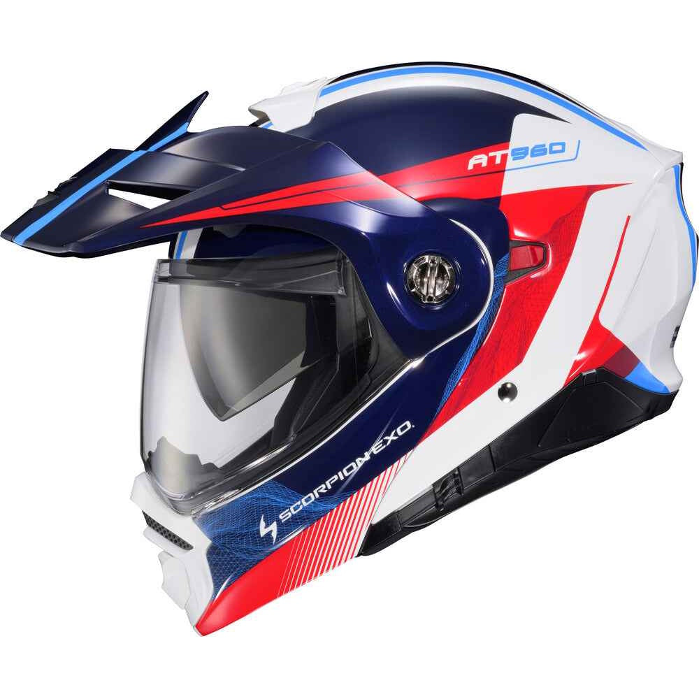 A full-face off-road motorcycle helmet in a white, navy blue, and red color scheme with blue and white stripes. The helmet features a clear visor, a dark visor, and the brand name 'Scorpion EXQ' and model 'AT960' printed on the shell.