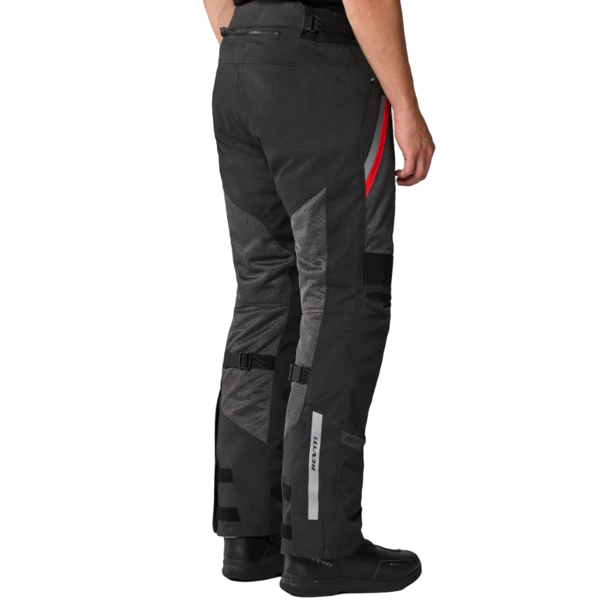 Person wearing black motorcycle pants with red and gray accents on a white background