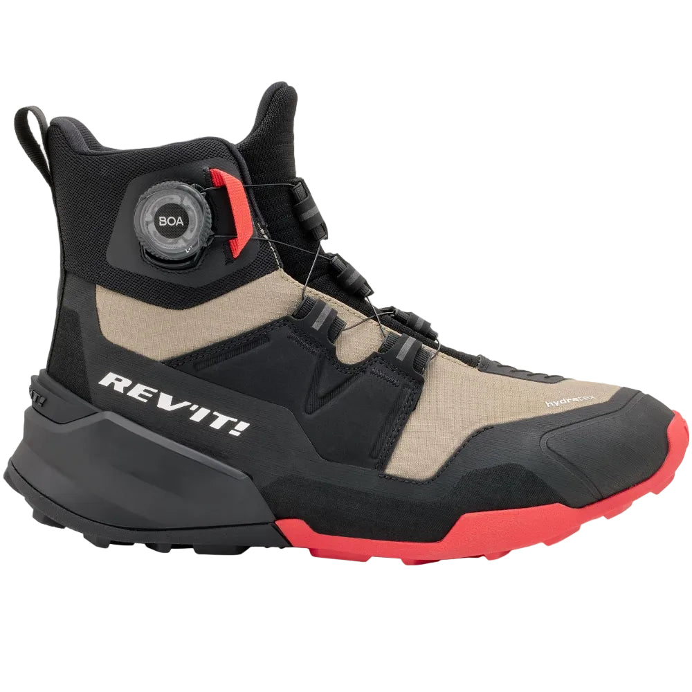 Black and beige boot with red accents on a light gray background, featuring the Rev'it! brand.