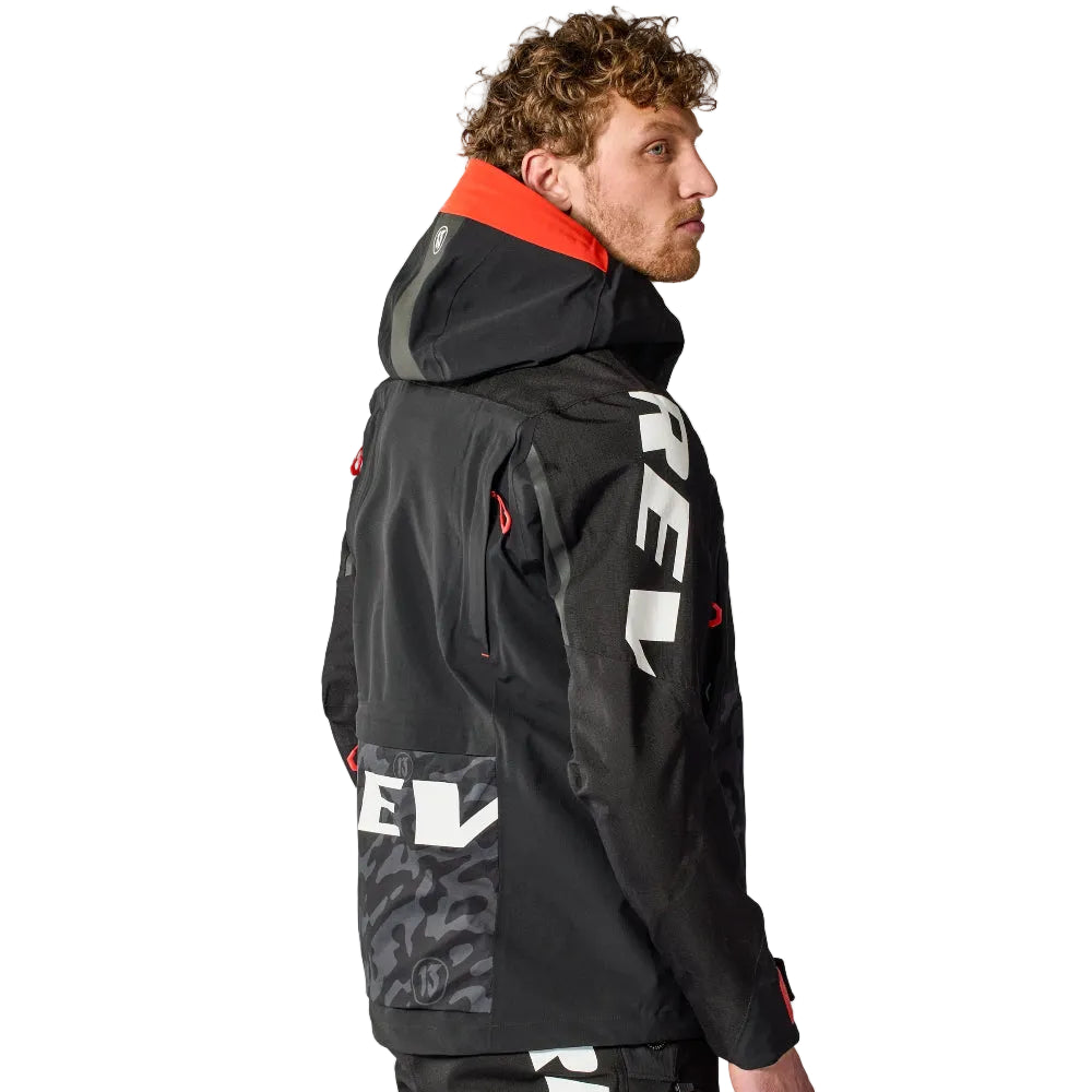 Person wearing a black jacket with red and white accents on a white background