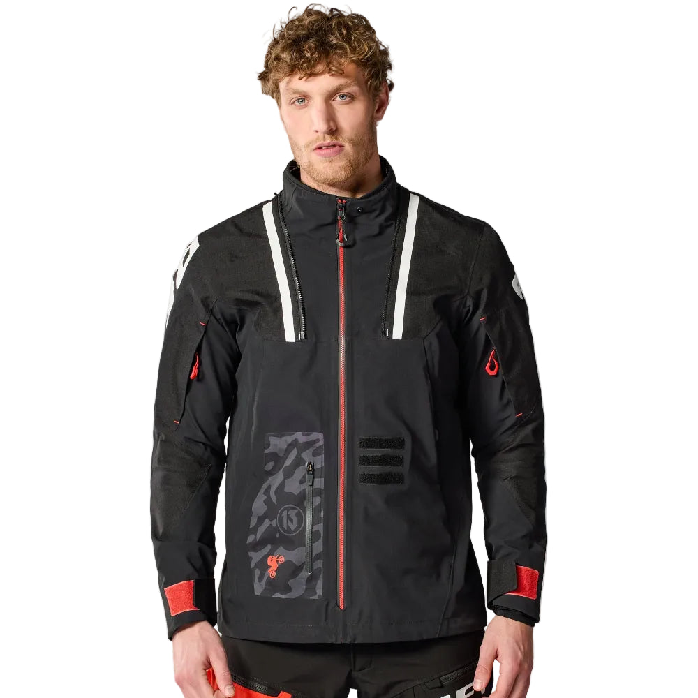 Man wearing a black and red jacket with visible branding on a white background