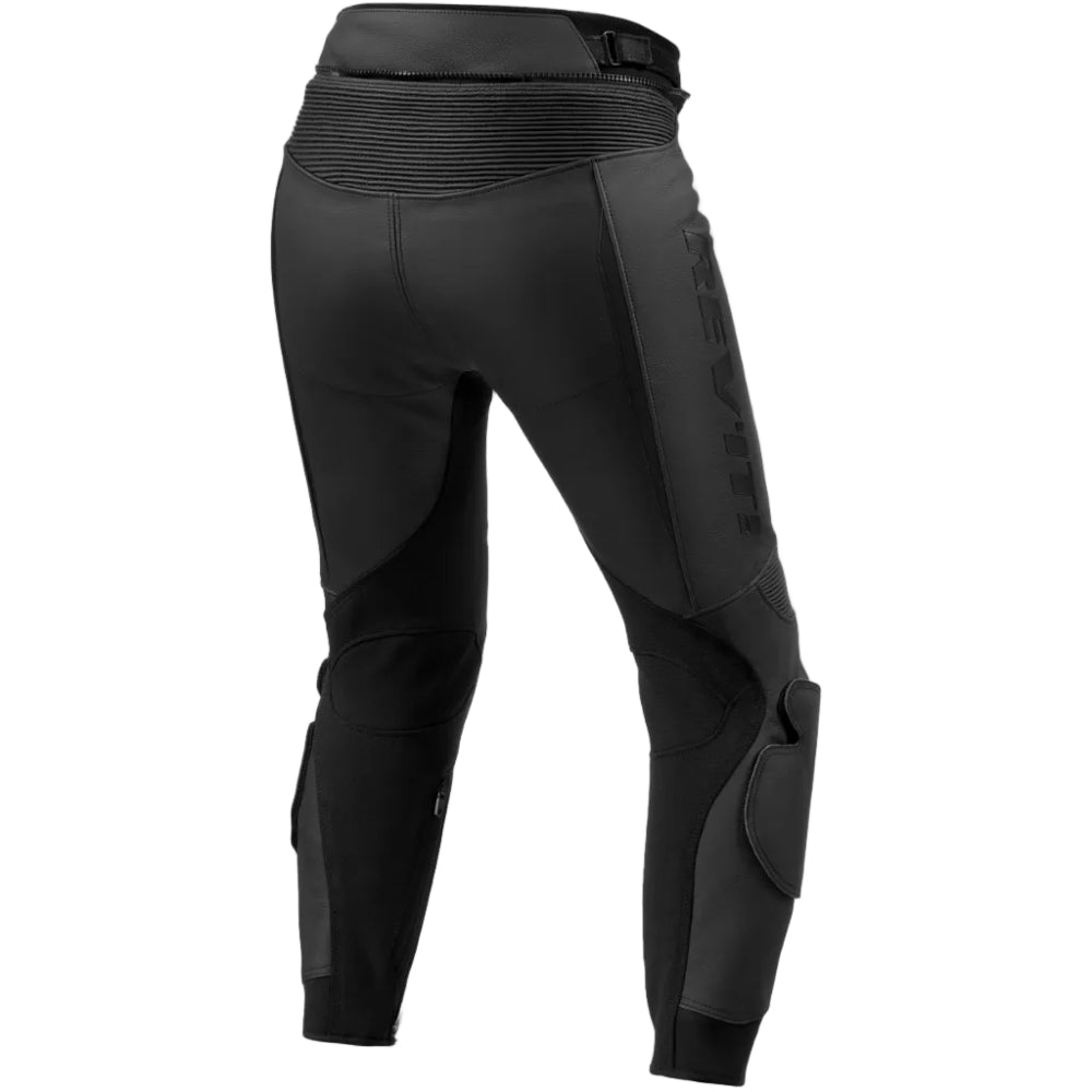 Black technical riding pants shown from the rear, featuring a high-waisted design with a ribbed waistband, side paneling, and protective knee guards, displayed on a clean white background.