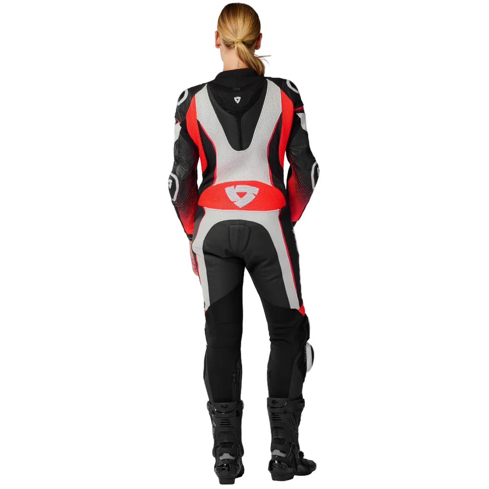 Person wearing a black, red, and gray motorcycle suit on a white background