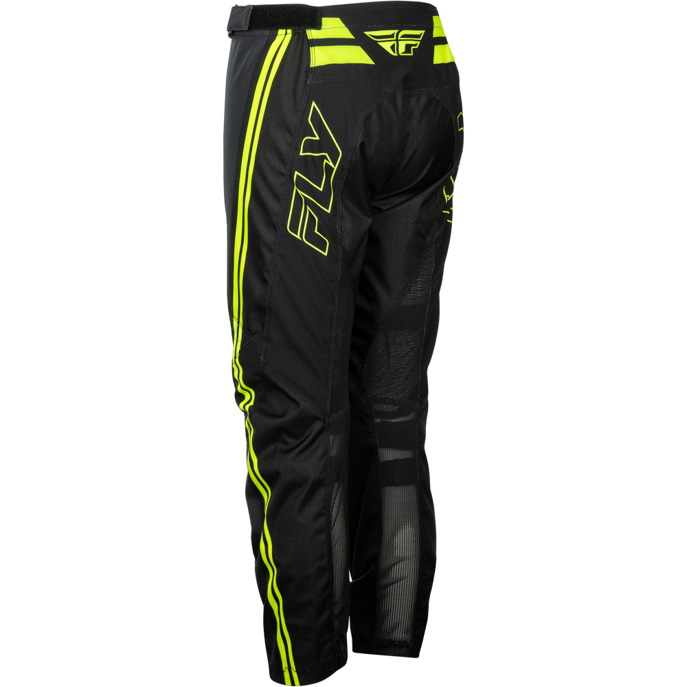 Black Fly Racing motocross pants with bright neon yellow-green side stripes and a large outlined 'FLY' logo on the left leg, shown from a three-quarters back angle on a white background.